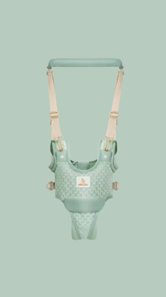 Green baby harness with beige straps on a light green background