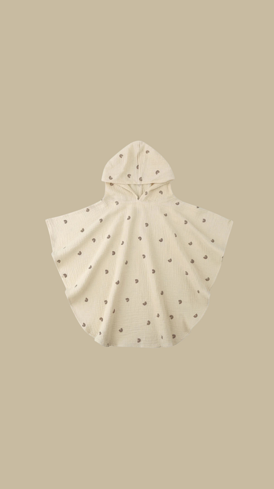 Baby poncho with hood on a beige background