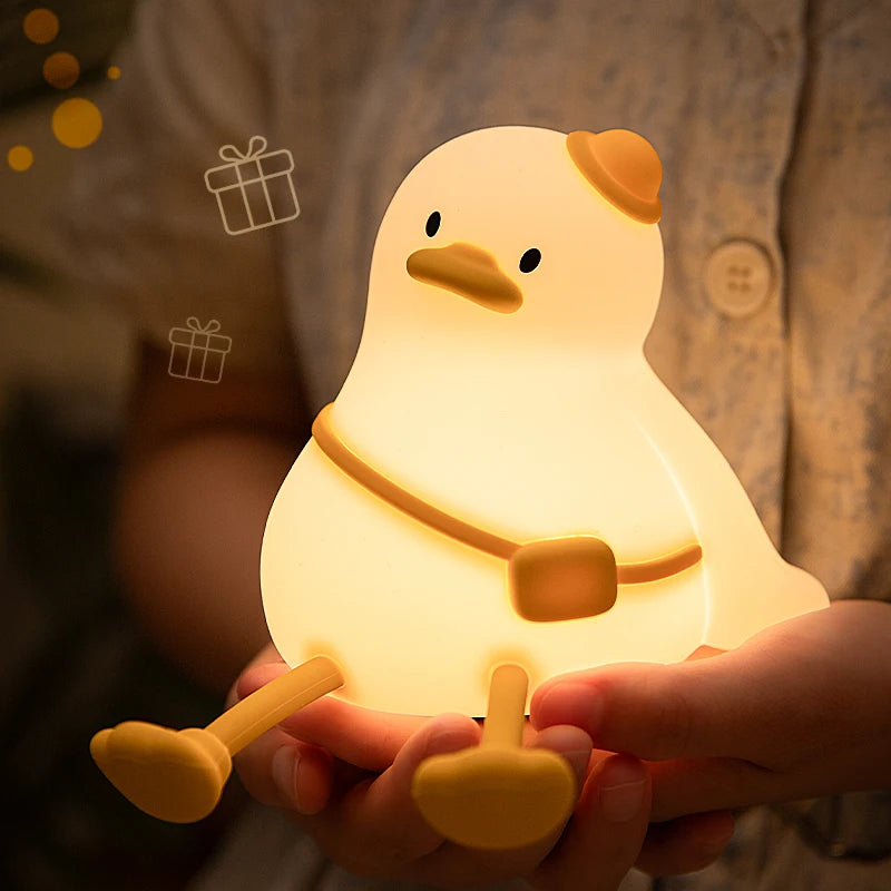 Cute duck-shaped night light held in a hand with a warm glow.